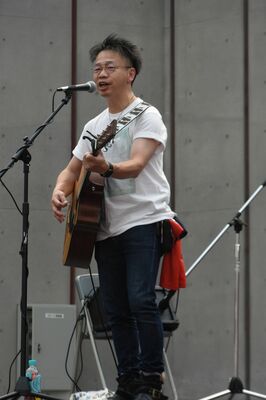 イベントで歌う伊原さん。ベルトには大芽君のサッカーの練習着を引っ掛けている＝１日午後、宇都宮市江野町