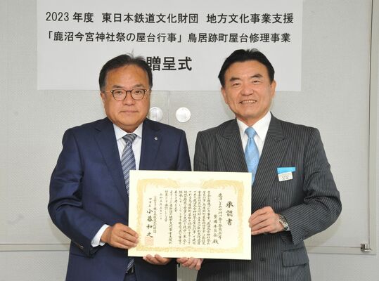 事業承認書を手にする鹿沼いまみや付け祭り祭用具等整備委員会の小林委員長（左）と東日本鉄道文化財団の太田専務理事