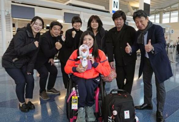 　出発前に関係者らと笑顔で記念写真に納まるパラアルペンスキー女子の村岡桃佳（中央）＝２８日、羽田空港