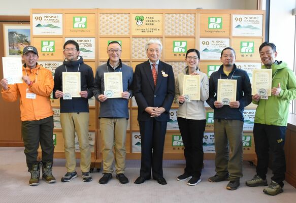 福田知事（中央）と認定ガイドになった６人＝14日午後、県庁