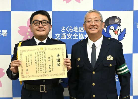 平山署長（右）から感謝状を受け取った菊池さん