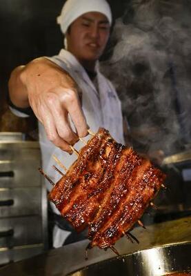 料理店で焼き上げられるウナギ=23日、東京都目黒区