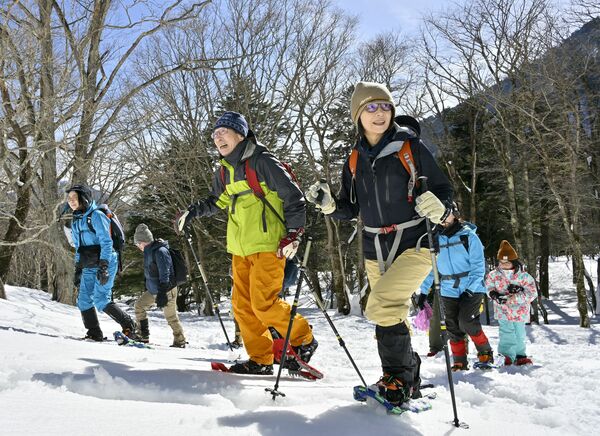 スノーシューで雪上散歩を楽しむ参加者=16日午前11時45分、日光市湯元
