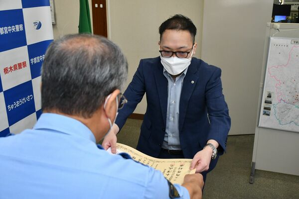 本澤署長（左）から感謝状を受け取る上吉原さん