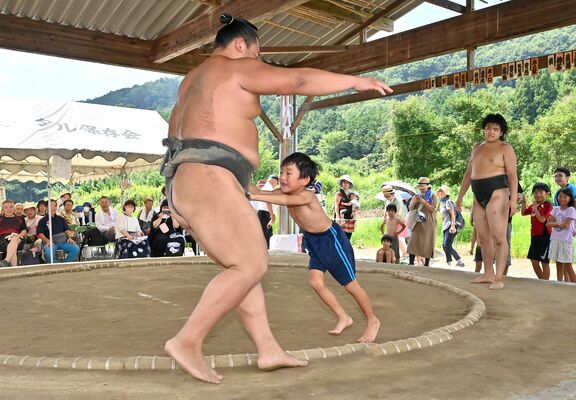 土俵で陸奥部屋の力士に挑む子ども＝20日午前10時55分、足利市名草上町