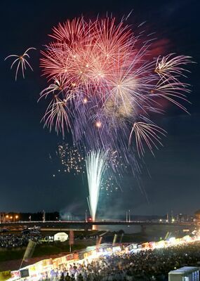 ５年ぶりに黒川河畔で打ち上げられた花火＝25日午後７時25分、鹿沼市朝日町（30秒間露光）