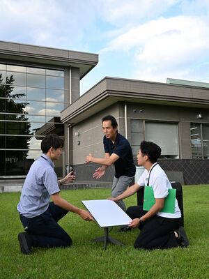 屋外の芝生広場にスターリンクのアンテナを設置する市職員＝９月３０日午後、宇都宮市富屋地区市民センター