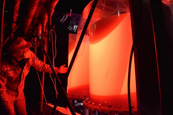 ＬＥＤ赤色レーザー光が照射されている透明タンク＝１月29日午後、小山市