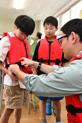 ライフジャケットを着用する児童たち