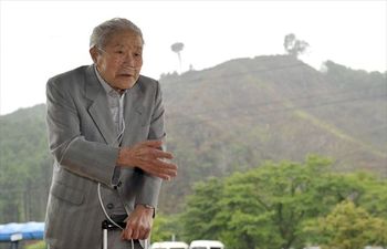 70年前、「口粟野防空監視哨」に立った黒子一郎さん。奥に見える城山の山頂に監視哨は建造された=19日、鹿沼市口粟野