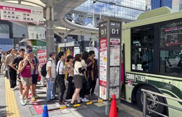 　観光バスに乗り込む旅行者ら＝７月、京都市