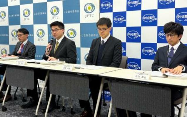 　記者会見する公取委の担当者ら＝２２日午後、東京都港区