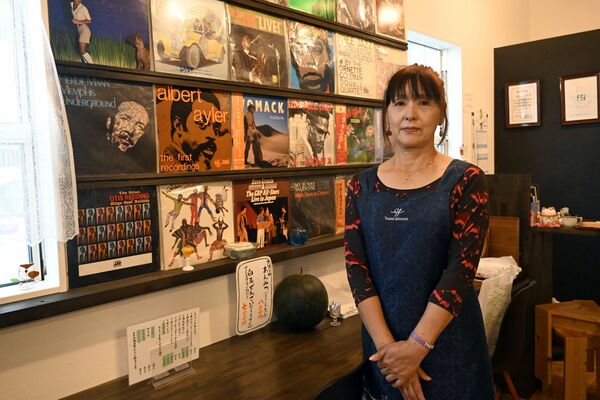 壁一面に飾られたレコードと、店主の鈴木さん