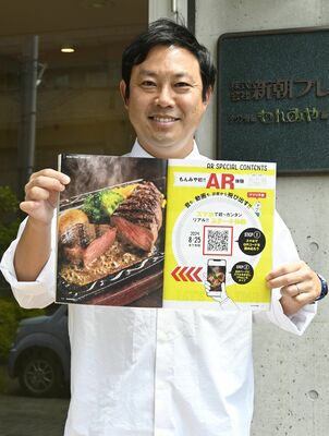 ６月号のＡＲ体験ページを開く橋本課長