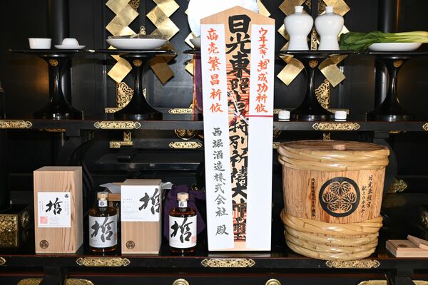 日光東照宮に献上されたウイスキー「哲」と御札、ウイスキーを熟成させた杉並木で作った和樽＝日光市
