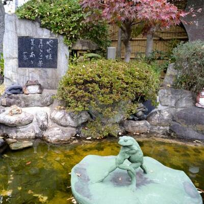 〈やせ蛙まけるな一茶是にあり〉の句碑と、カエルが相撲を取るオブジェ=東京都足立区