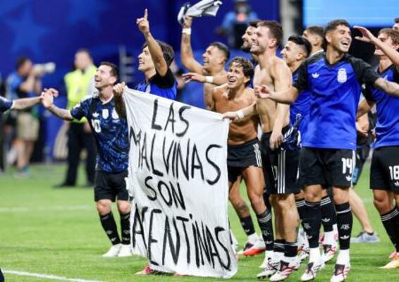 イングランド戦後に、フォークランド諸島に関する旗を掲げて喜ぶアルゼンチンの選手たち=アトランタ(ロイター=共同)