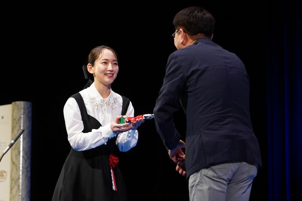 トロフィーを受け取る吉岡さん（左）＝16日夜、東京都千代田区
