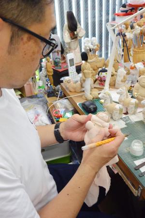 江戸木目込み人形の「力士ペーパーウエイト」を制作する塚田真弘さん=東京都墨田区