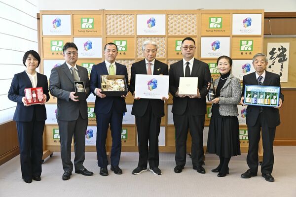 「栃木の逸品」に選ばれた商品を福田知事(中央)に報告した事業者たち=27日午前、県庁