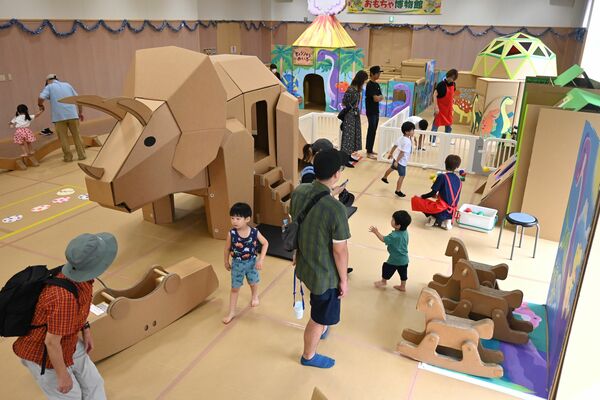 段ボールの遊具で遊ぶ親子連れ