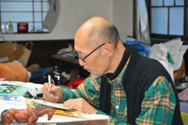 　執筆する藤田和日郎さん