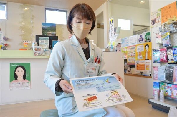 緊急避妊薬の説明書きを手にするミドリ薬局の猪瀬さん＝12月上旬、宇都宮市西川田５丁目