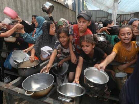 　食料配給を待つ子どもたち＝１６日、ガザ中部ヌセイラト難民キャンプ（ゲッティ＝共同）