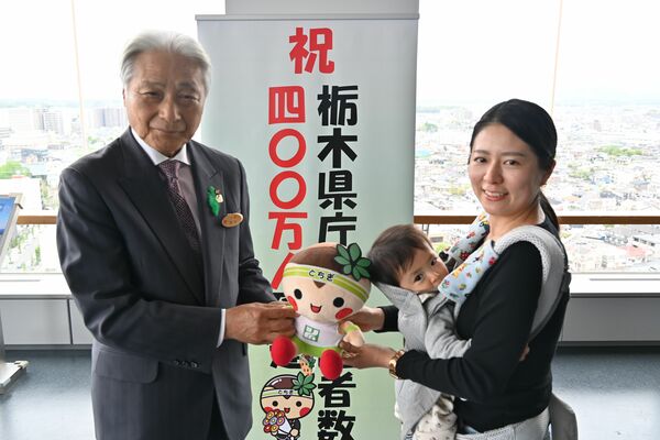 福田知事（左）から記念品を受け取る上野さん親子＝23日午後、県庁