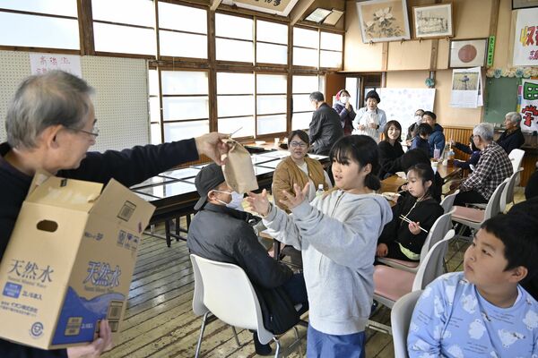 活動した田んぼで収穫したコメを受け取る子どもら