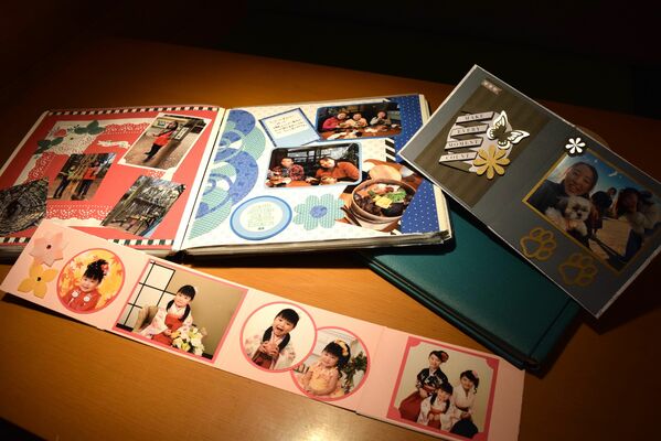 これまでに製作したアルバムを手にする篠原さん
