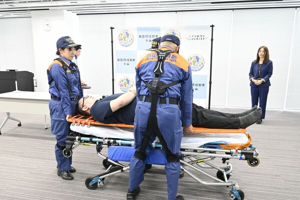 パワーアシストスーツを着用して傷病者の搬送を実演する小山市消防本部の職員