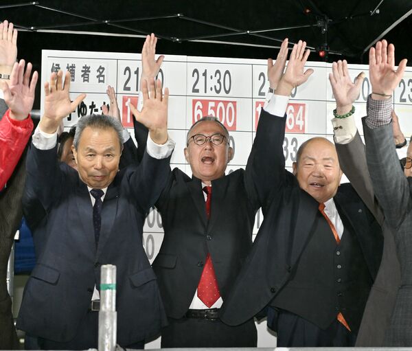 再選を果たし、万歳する金子裕氏（中央）＝13日午後10時10分、佐野市植下町、磯真奈美撮影
