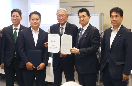　火山防災に関する決議を受け取る赤間防災相（右から２人目）＝１８日午後、国会