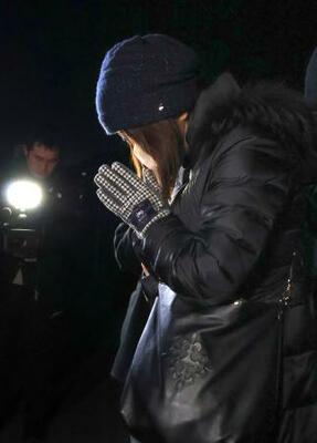 　１９４キロ死亡事故現場で手を合わせる遺族＝９日夜、大分市