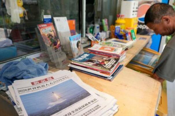 売店で売られる、中国軍が潜水艦発射弾道ミサイル(SLBM)を発射した写真を1面に掲載した中国紙=7日、北京(共同)