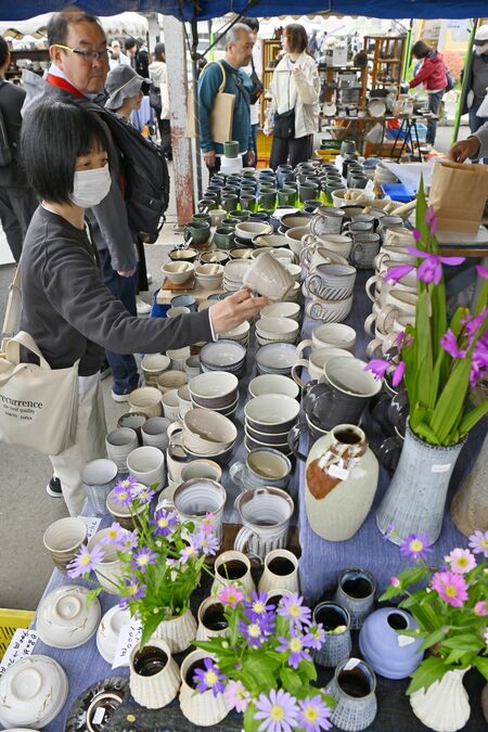 ずらりと並んだ陶器を手に取る来場者＝29日午前11時15分、益子町益子