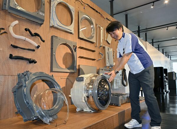 洗濯乾燥機の部品が展示されたブース=16日午前、宇都宮市平出工業団地