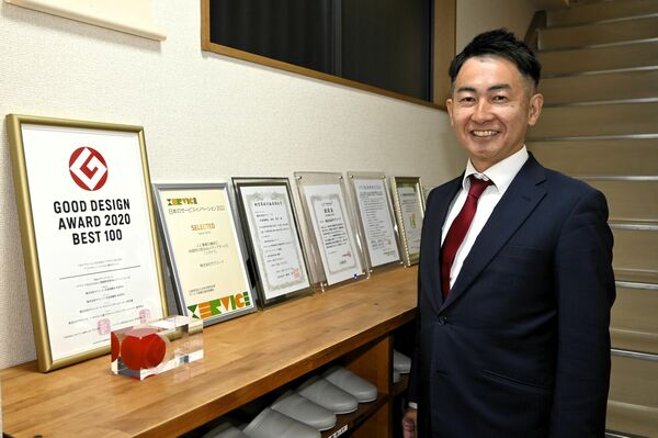 入り口に掲げられた「ツグナラ」のグッドデザイン賞などの盾と水沼社長
