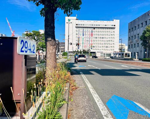 国道56号の終点付近の距離標（キロポスト）＝５月２日午後、松山市二番町４丁目（車とバイクのナンバープレートを画像加工しています）