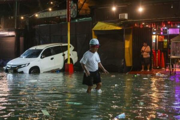 　台風が直撃し浸水した道路を歩く男性＝９日、マニラ首都圏（ゲッティ＝共同）