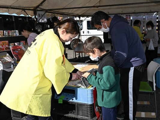 新聞紙を使ったスリッパ制作に取り組む参加者たち