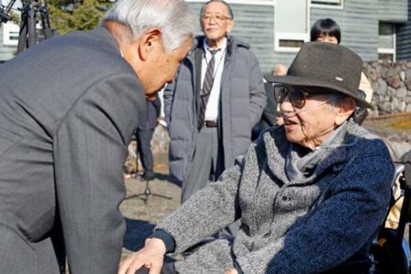 石碑の除幕式後、関係者と談笑する倉本聰さん(右)=16日午前、北海道富良野市