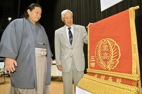 黒羽高の校章がデザインされた化粧まわしを受け取った三田関(左)=8日午後2時45分、大田原市本町1丁目