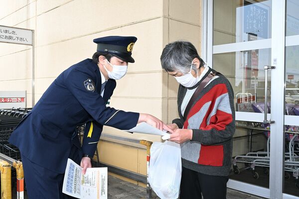 事件の情報提供を呼びかける警察官=14日午前、那須塩原市太夫塚6丁目