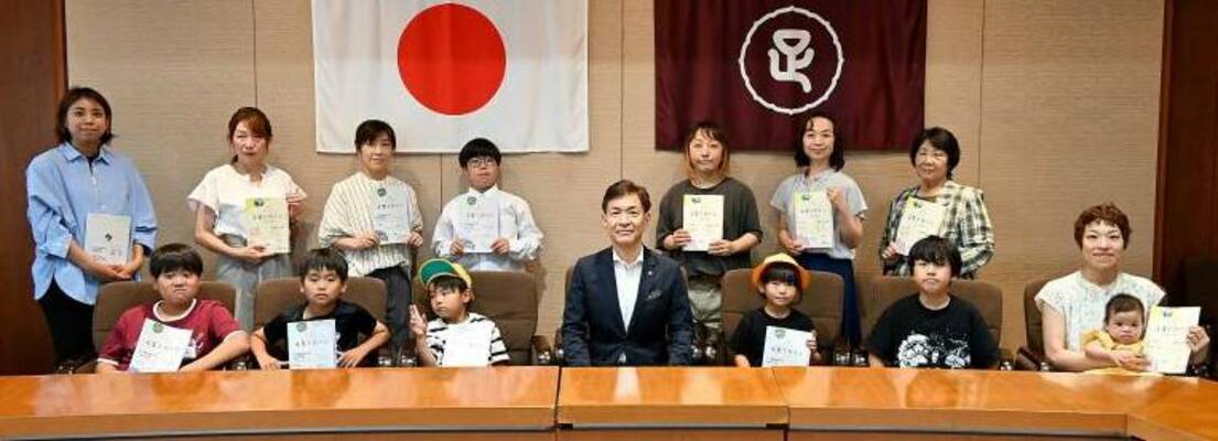早川市長(前列中央)に育児情報誌を贈呈した「あしかが子育て応援ネット」のメンバー