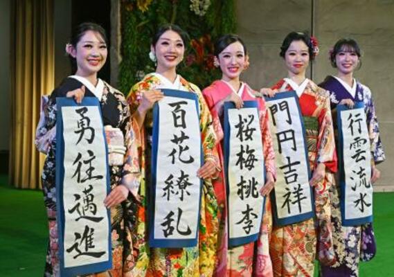 福島県いわき市の温泉施設スパリゾートハワイアンズで、振り袖姿で書き初めを披露する(左から)MOMOKAさん、MIMIさんら20歳になるフラガール=10日午前