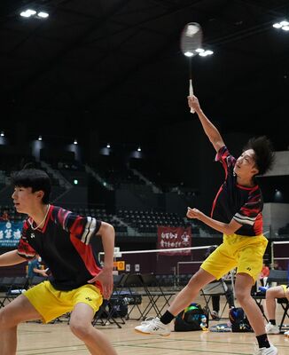 バドミントン男子優勝決定戦　宇南の佐藤（右）がスマッシュを放つ。左は岡島＝日環アリーナ栃木