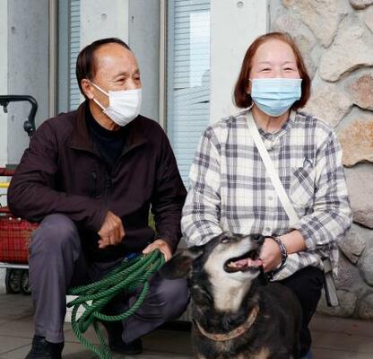 　愛犬のミノと約１日半ぶりに再会した渡辺敏夫さん（左）と妻の寿賀子さん＝２０日午前、大分市佐賀関