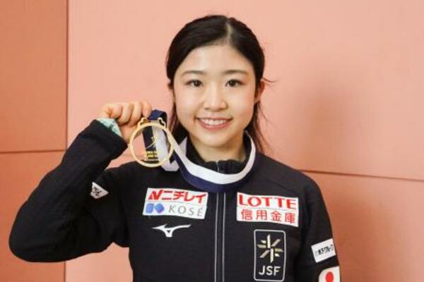 帰国し、撮影に応じるフィギュアスケート女子の千葉百音=24日、関西空港